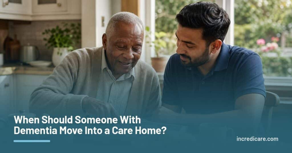 An older man and his caregiver look through a photo album together at a sunlit kitchen table.